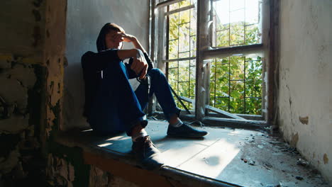 Teenager-with-a-gun-sits-in-an-abandoned-building-2