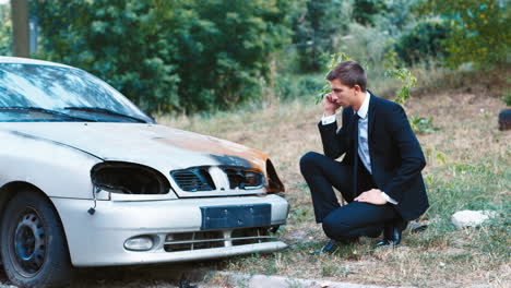 A-man-in-a-suit-inspects-a-car-after-an-accident