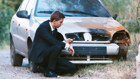 A-man-in-a-suit-inspects-a-car-after-an-accident-2