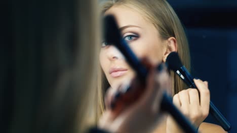 Attractive-woman-corrects-makeup-in-front-of-the-mirror-1