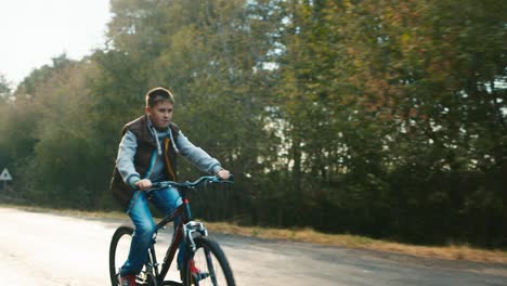 Un-Adolescente-Monta-Una-Bicicleta-En-Una-Carretera-Rural