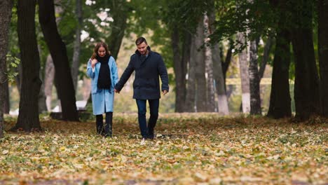 A-young-couple-strolling-through-the-autumn-park