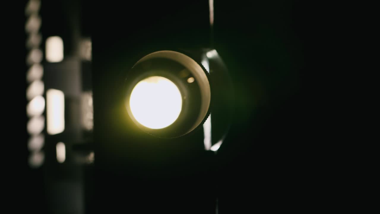 Premium stock video Closeup of vintage projector light flickering in the dark