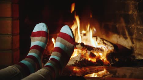 A-woman-warms-her-feet-by-the-fireplace