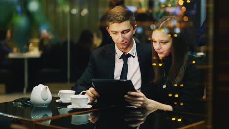 A-couple-in-love-rests-in-a-cafe-and-uses-a-tablet-3