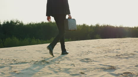 A-businessman-with-a-case-in-his-hand-walks-along-a-sandy-beach-1
