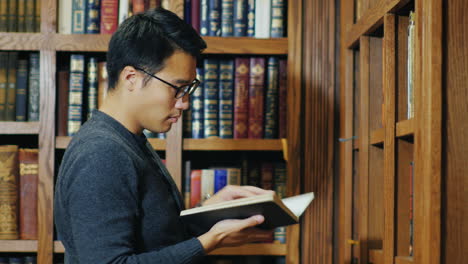 Good-Looking-Asian-Man-In-Glasses-Reading-A-Book-In-The-Library-2