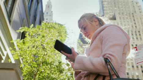 Eine-Geschäftsfrau-Benutzt-Ein-Tablet-Auf-Einer-Belebten-Straße-Im-Geschäftigen-Verkehr-In-Manhattan
