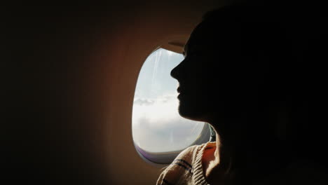 A-Female-Passenger-Looks-Out-The-Window-Of-The-Plane-To-The-City-Below-2