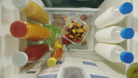 Midnight-Snack-View-From-Inside-The-Refrigerator---Women's-Hands-Take-Sweets-From-A-Plate