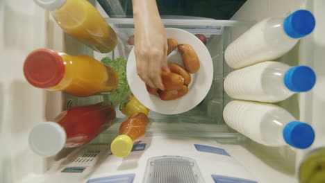 Midnight-Snack-View-From-Inside-The-Refrigerator---Women's-Hands-Take-Sweets-From-A-Plate-1