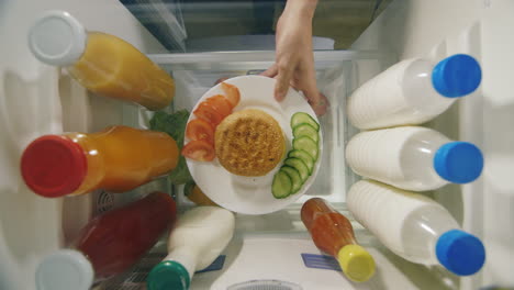 A-Man's-Hand-Takes-A-Burger-And-A-Sauce-From-The-Refrigerator