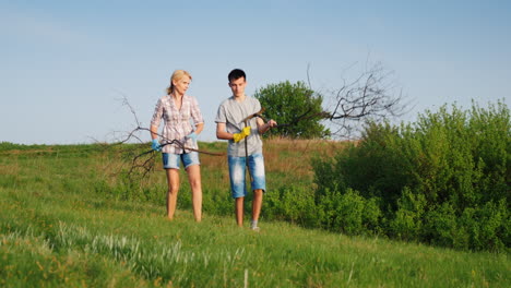 A-Woman-With-Her-Teenage-Son-Is-Cleaning-Up-The-Garbage-In-The-Meadow
