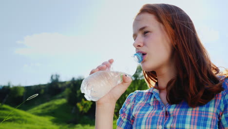 A-Teenager-Drinks-Clean-Water-From-A-Bottle-On-A-Picnic-In-A-Picturesque-Place