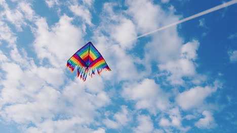 An-Air-Kite-Flies-Against-A-Blue-Sky-With-White-Clouds