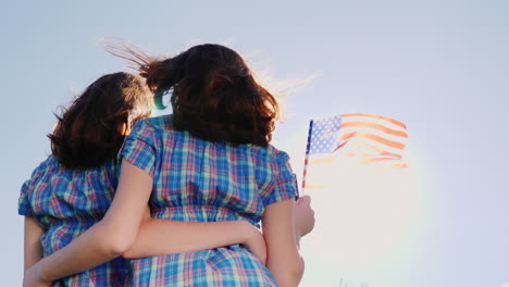Zwei-Weibliche-Zwillinge-Mit-Einer-Amerikanischen-Flagge-Auf-Einem-Blauen-Himmelshintergrund-2