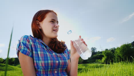 A-Teenager-Drinks-Clean-Water-From-A-Bottle-On-A-Picnic-In-A-Picturesque-Place-2