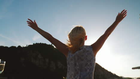 A-Woman-Dances-On-A-Yacht-Against-The-Backdrop-Of-The-Setting-Sun