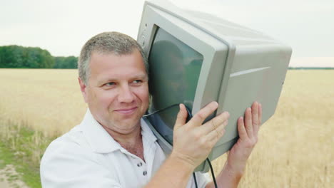 A-Cool-Middle-Aged-Man-Carries-An-Old-Tv-Set-On-His-Shoulder