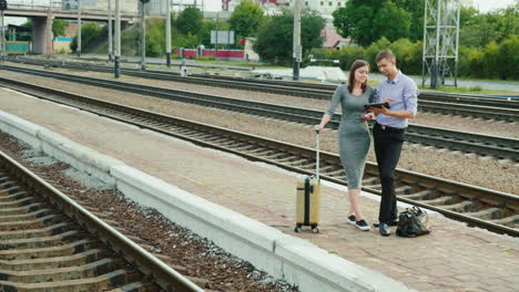 A-Man-And-A-Woman-Are-Standing-On-A-Railway-Platform-In-The-Countryside