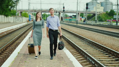A-Young-Couple-With-Bags-Goes-On-The-Platform-At-The-Station