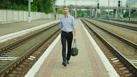 A-Good-Looking-Young-Businessman-Walks-Along-The-Railway-Platform-1