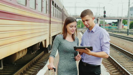 Young-Businesspeople-Use-A-Tablet-At-A-Railway-Station