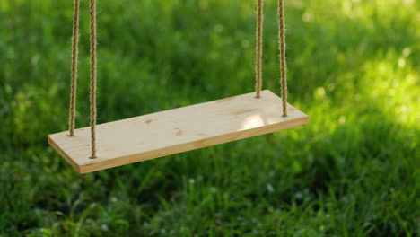 Wooden-Swing-On-A-Background-Of-Green-Grass