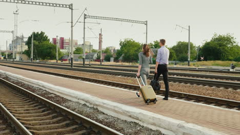 Two-Businessmen-With-Luggage-Go-Along-The-Railroad